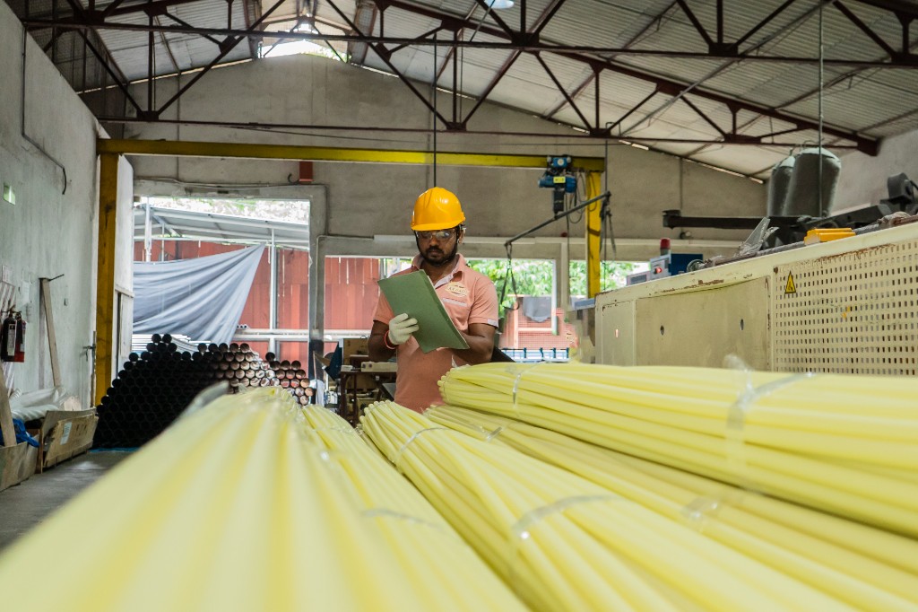 Quality inspector reviewing yellow conduit bundles in the warehouse
