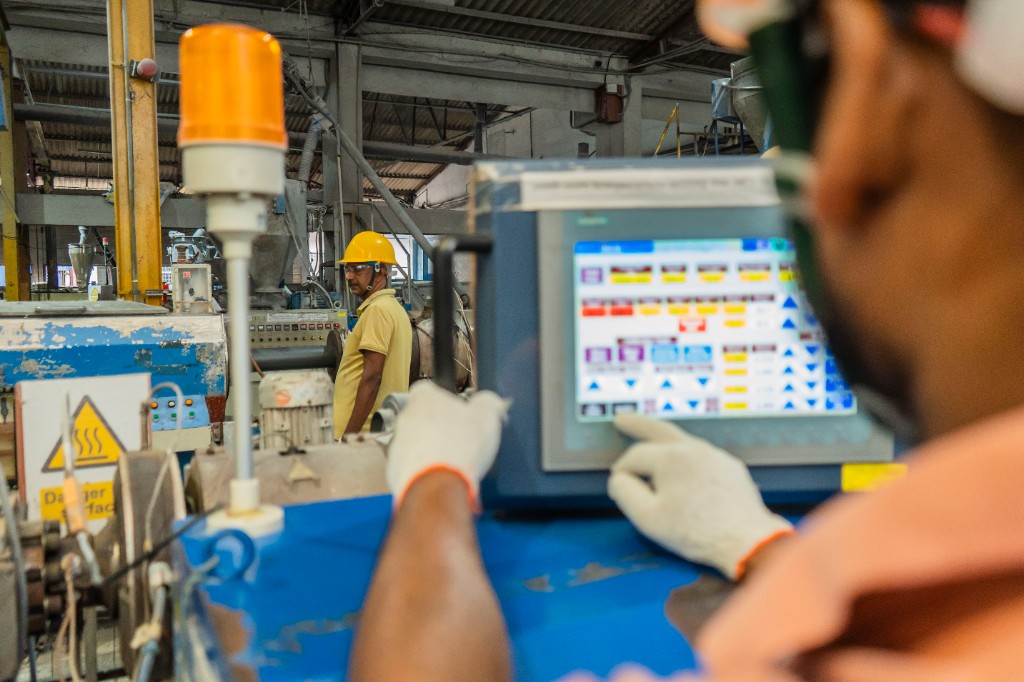 National PVC employee operating manufacturing equipment